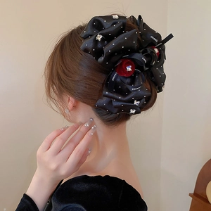 Detail of silk bow hair clip with red velvet rose, rhinestones and CHANGE ribbon
