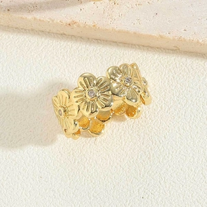 Close-up of 14K gold plated flower ring with sparkling zircon stones on stone surface