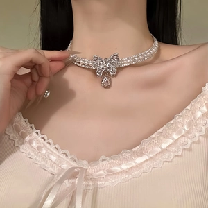 Elegant silver bow choker with pearls and diamonds worn by model for fashion styling