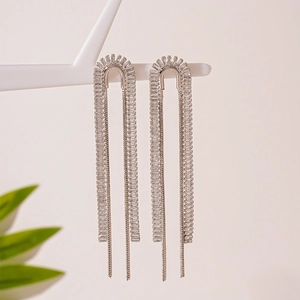 Detailed close-up of zircon n-shaped fringe earrings with hanging silver chain tassels