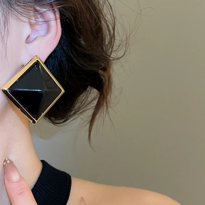 Gros plan d'un mannequin portant des boucles d'oreilles rétro carrées en résine