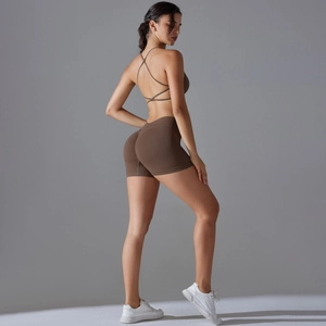 Detail of dark brown criss-cross back sports bra and ruched butt-lift yoga shorts set