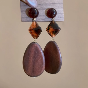 Detailed view of vintage wood and resin drop earrings with geometric bead layering