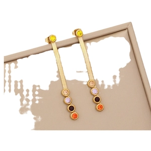Elegant gold tassel earrings with colorful round gemstones on a beige textured tray