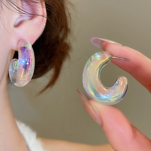 Close-up of iridescent acrylic U-shaped earrings showing colorful aurora finish and detail