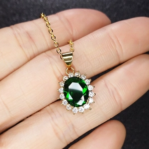 Classic sunburst emerald green pendant necklace with halo of white zircon diamonds