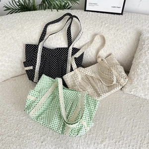 Three-color polka dot canvas tote bags with delicate lace trim on a soft sofa