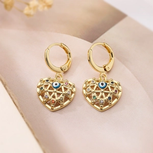 Detail view of gold heart earrings with evil eye motif and colorful crystal accents