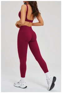 Dettaglio dei leggings yoga bordeaux con tasca laterale e vita a V sulla schiena
