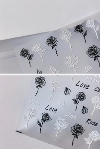 Macro detail of 5D embossed nail stickers featuring black and white roses and butterflies