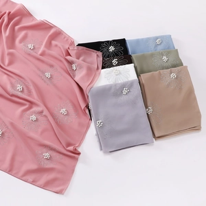 Detail of chiffon hijab with rhinestones, pearls and flower patterns in multiple colors