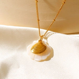 Macro de collier coquillage doré avec couche en nacre blanche et chaîne à perles