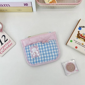 Detail of pink quilted coin purse featuring heart stitching and transparent card slot