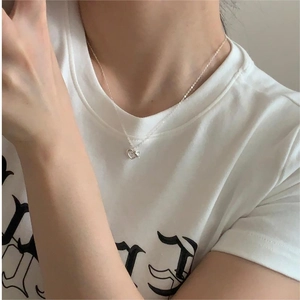 Minimalist S925 silver heart necklace shown on a model's collarbone with white tee
