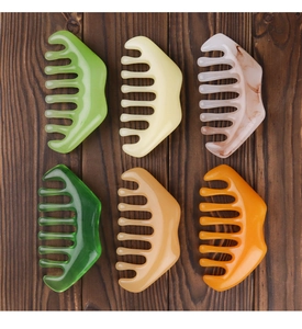 Various colorful wide-tooth scalp massage combs displayed on a wooden surface