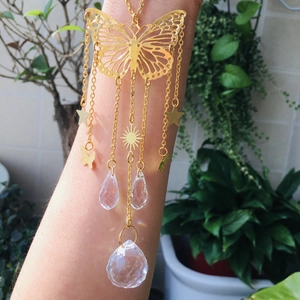 Detailed shot of a golden butterfly suncatcher with crystal prisms and hanging star charms
