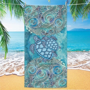 Detail of microfiber beach towel featuring turtle prints hanging on a palm tree