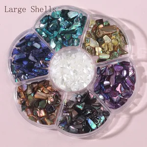 Macro view of natural crushed shell pieces in seven colors inside a petal-shaped storage box
