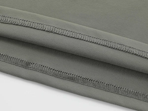 Close-up of sage green knit fabric showing premium stitching and textured ribbed details