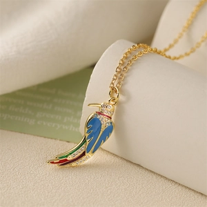 Golden necklace featuring a blue enamel bird pendant with crystals on a beige background