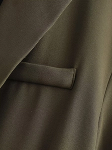 Vue détaillée du revers et de la poche d'un blazer vert olive en tissu sergé premium
