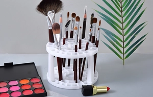 Macro shot of white circular makeup brush holder with multiple holes and organized tools