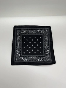 Flat lay macro of a black paisley bandana with white floral patterns on fabric