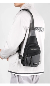 Detail of man wearing black and gray crossbody chest bag with adjustable strap