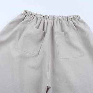 Dettaglio dell'elastico in vita e delle tasche posteriori sui pantaloni di lino