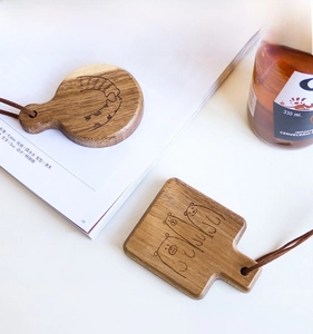 Detail of wooden coasters with engraved animal patterns and leather ropes for hanging