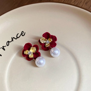 Detail of vintage velvet flower earrings with crystals and pearls on a ceramic dish