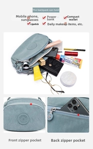 Detailed view of smog blue nylon crossbody bag with multi-layer zipper storage