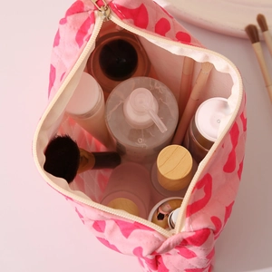 Pink heart pattern makeup bag with zipper closure showing spacious inner compartment