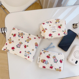 Detailed macro view of quilted floral makeup bag set showing soft cotton texture and retro prints