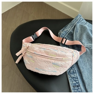 Detail of pink embossed waist bag featuring dual F pattern on a black leather chair