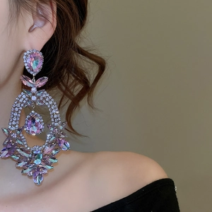 Close-up of elegant purple rhinestone teardrop earrings worn by a model