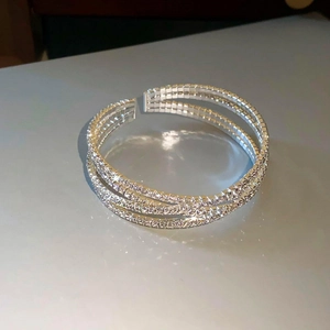 Detailopname van drielagige zilveren open armband met glinsterende zirkonia inlay