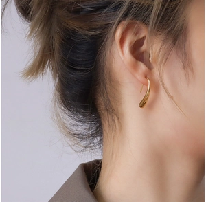 Detail view of a 18K gold plated teardrop hook earring on a female model