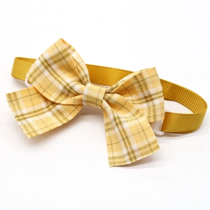 Adjustable yellow plaid bowtie for pets with a durable fabric strap on white background