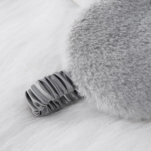 Soft grey faux fur sleep mask with satin elastic strap on a plush white background