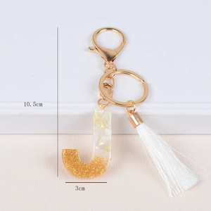Detail of resin letter J keychain with gold foil flakes and white tassel dimensions