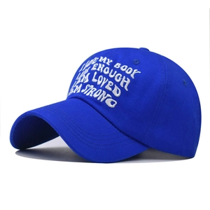 Detail der weißen Bestickung mit Zitaten auf einer königsblauen Baumwoll-Baseballkappe