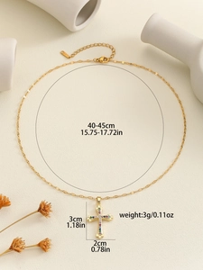 Detail view of gold cross necklace with multicolored zircons and dimension markers