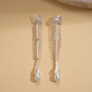 Close-up of silver fishbone earrings with sparkling zircons and teardrop pearl drops