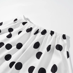 Détail du motif à pois noirs sur tissu blanc avec bordures élastiques volantées
