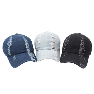 Detail showing distressed holes and frayed texture on washed denim baseball caps