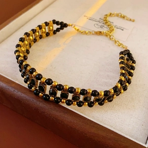 Detail of vintage beaded choker necklace with black gems and gold hollow accents