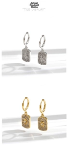 Close-up of gold and silver square pendants with micro-pave zircons and star motif