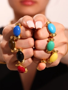 Detailed shot of 18K gold plated bracelets with colorful oval resin stones on wrist