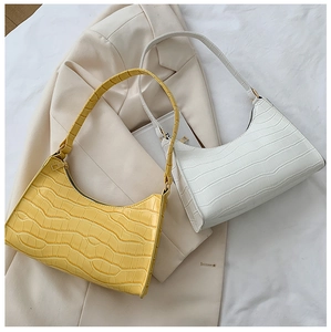 Macro view of croissant bag in crocodile pattern leather and smooth zipper detail